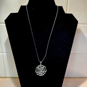 Silver flower pendant on black rope necklace